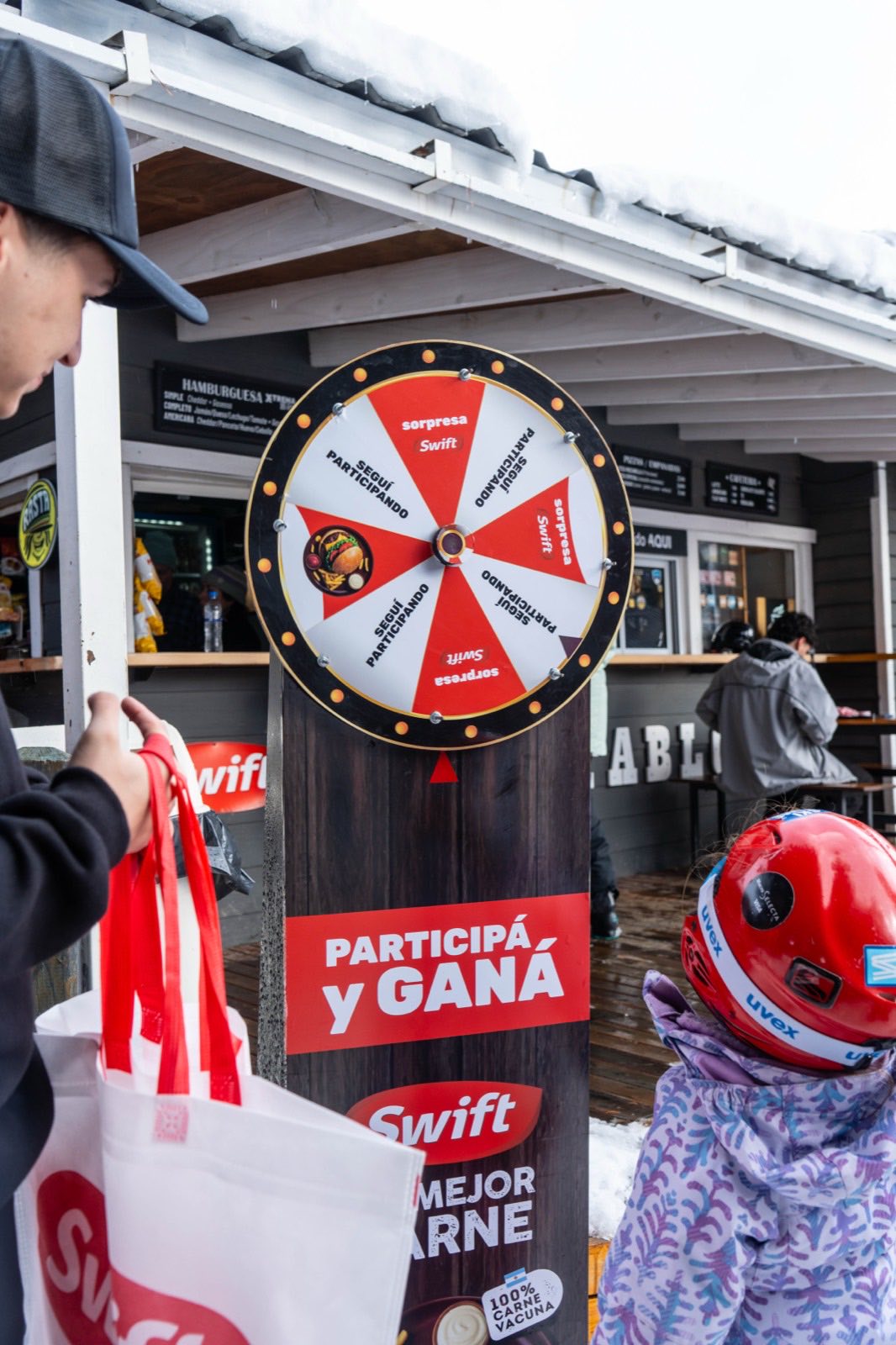 Ruleta promocional Participá y Ganá de Swift con público en el centro de esquí Cerro Catedral, Bariloche
